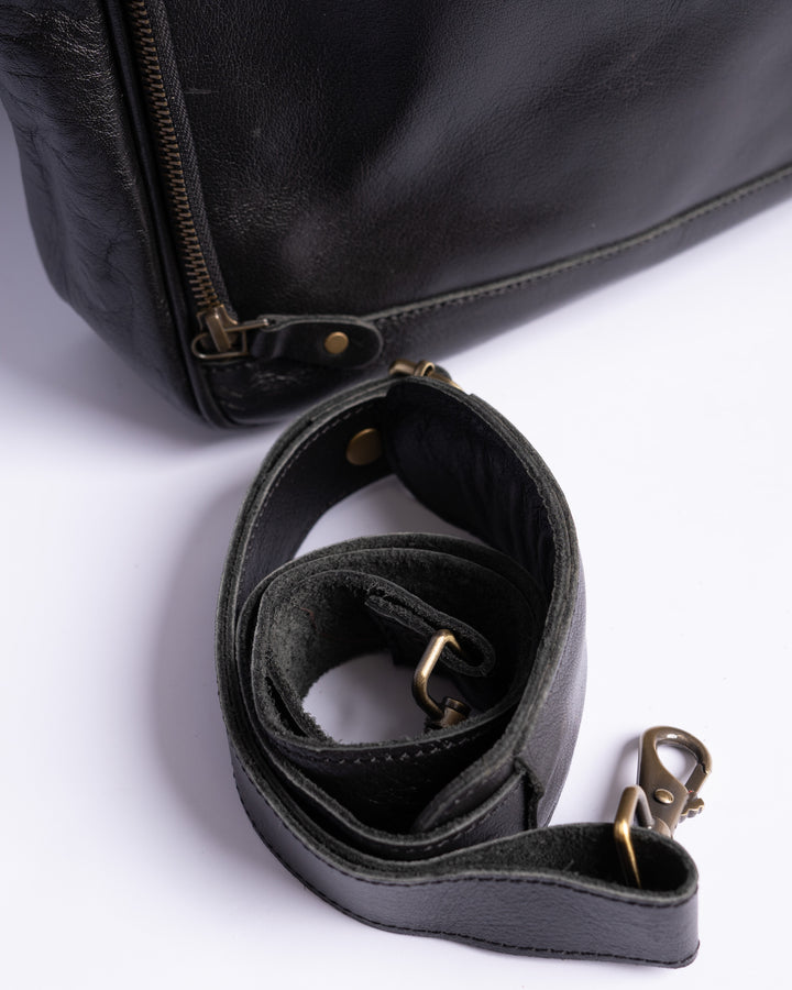 Black leather bag with a strap on a white background